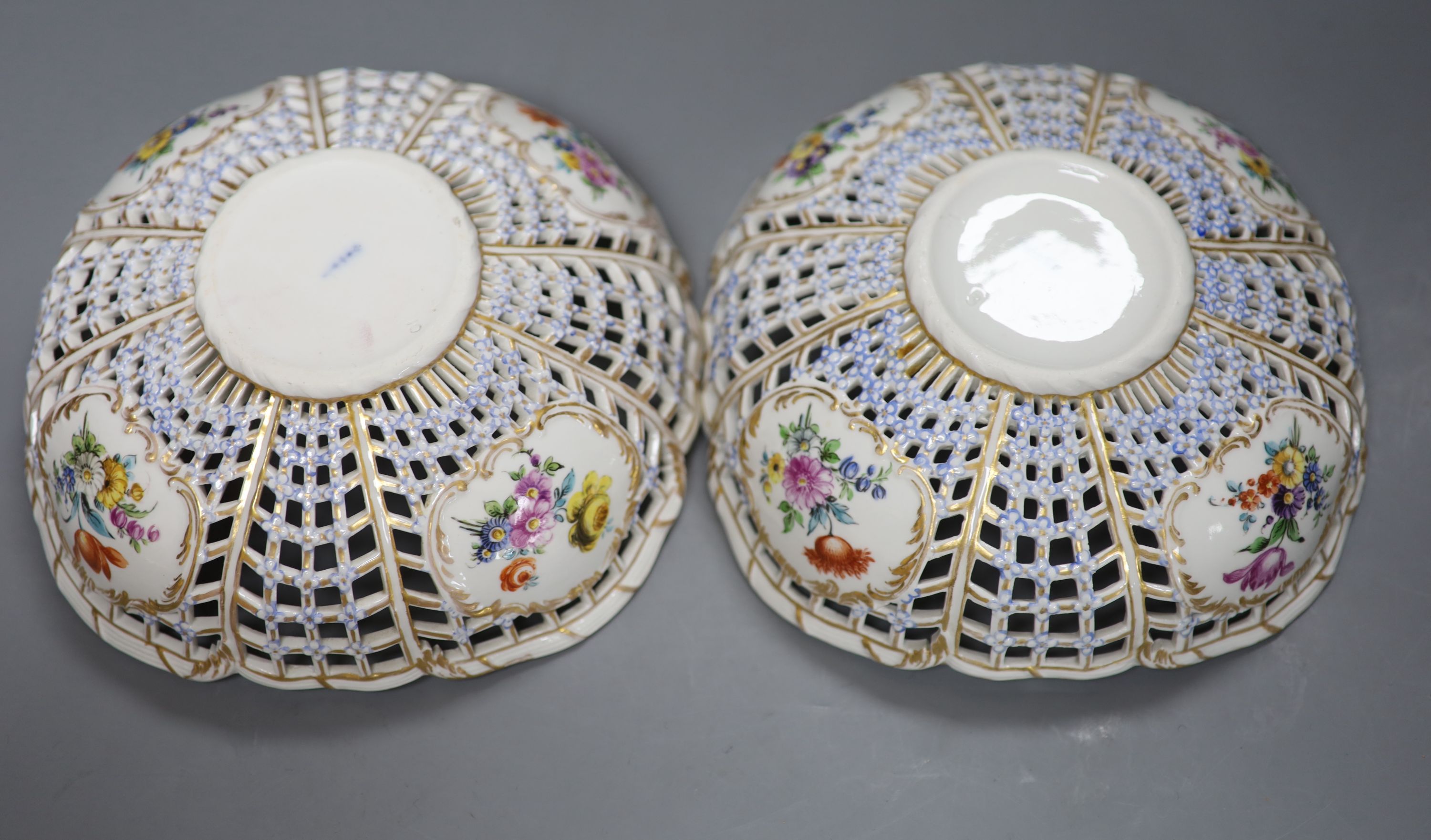 A pair of fine Continental pierced baskets, the panels painted with birds or flowers inside and out, blue Berlin style mark